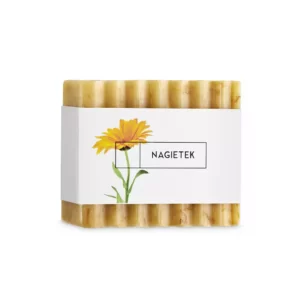 Ręcznie robione mydło w kostce o karbowanej powierzchni i żółtawym kolorze z kwiatem nagietka na etykiecie